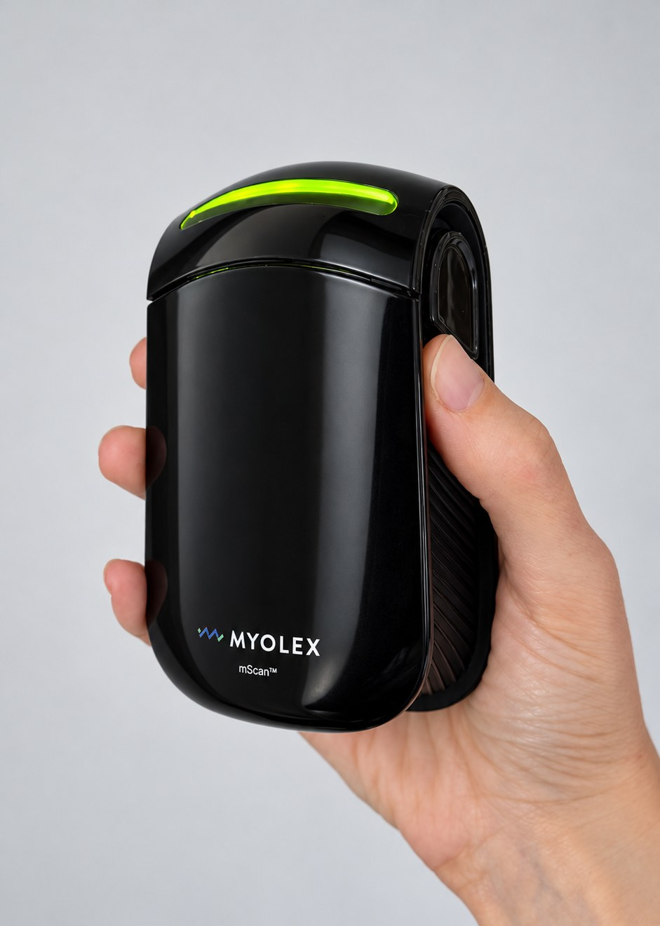 The glossy black mScan device held in one hand, its green status light on